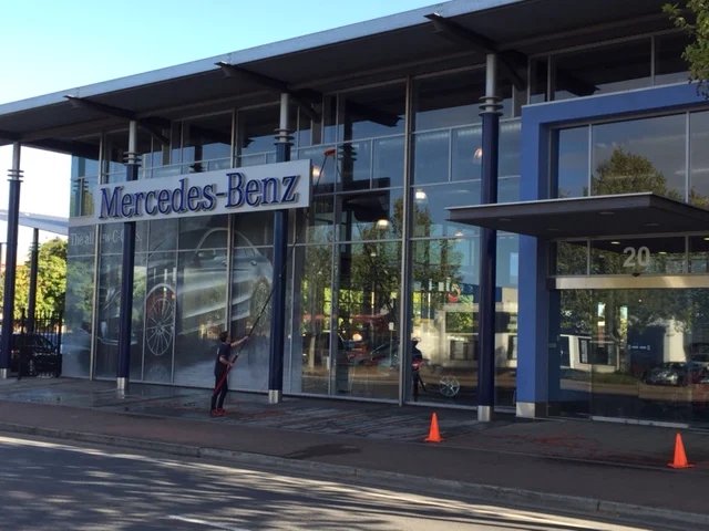 Window cleaner washing the glass of a car showroom in Adelaide