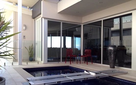 Sparkling glass doors around a home swimming pool